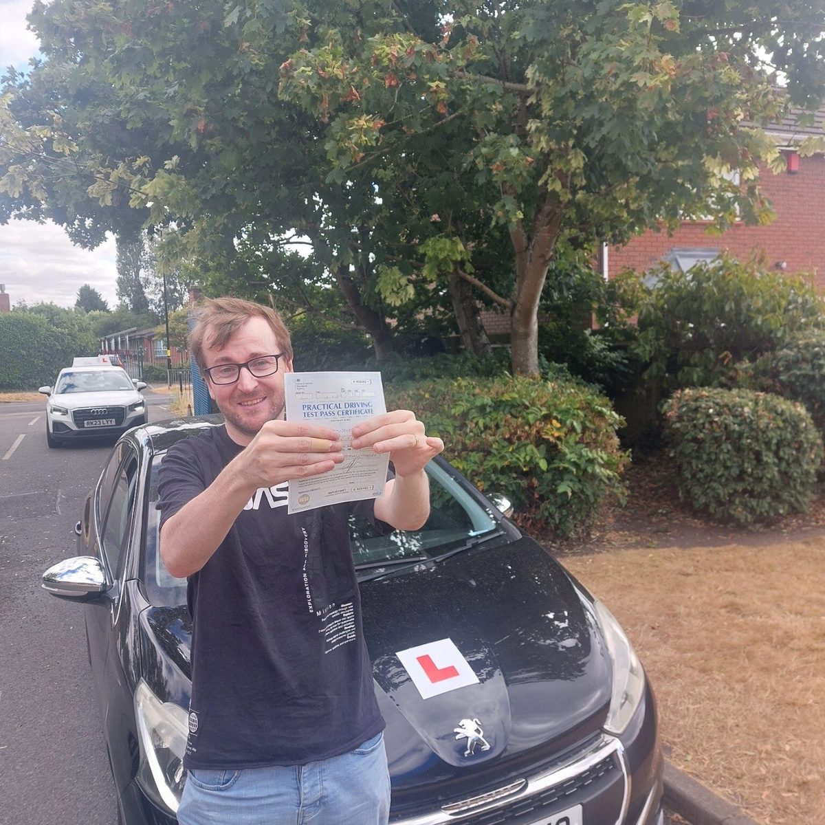 Successful Mals Driving School pupil holding a practical driving test pass certificate