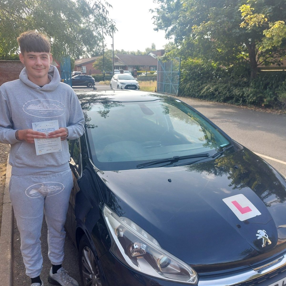 Successful Mals Driving School pupil holding a practical driving test pass certificate