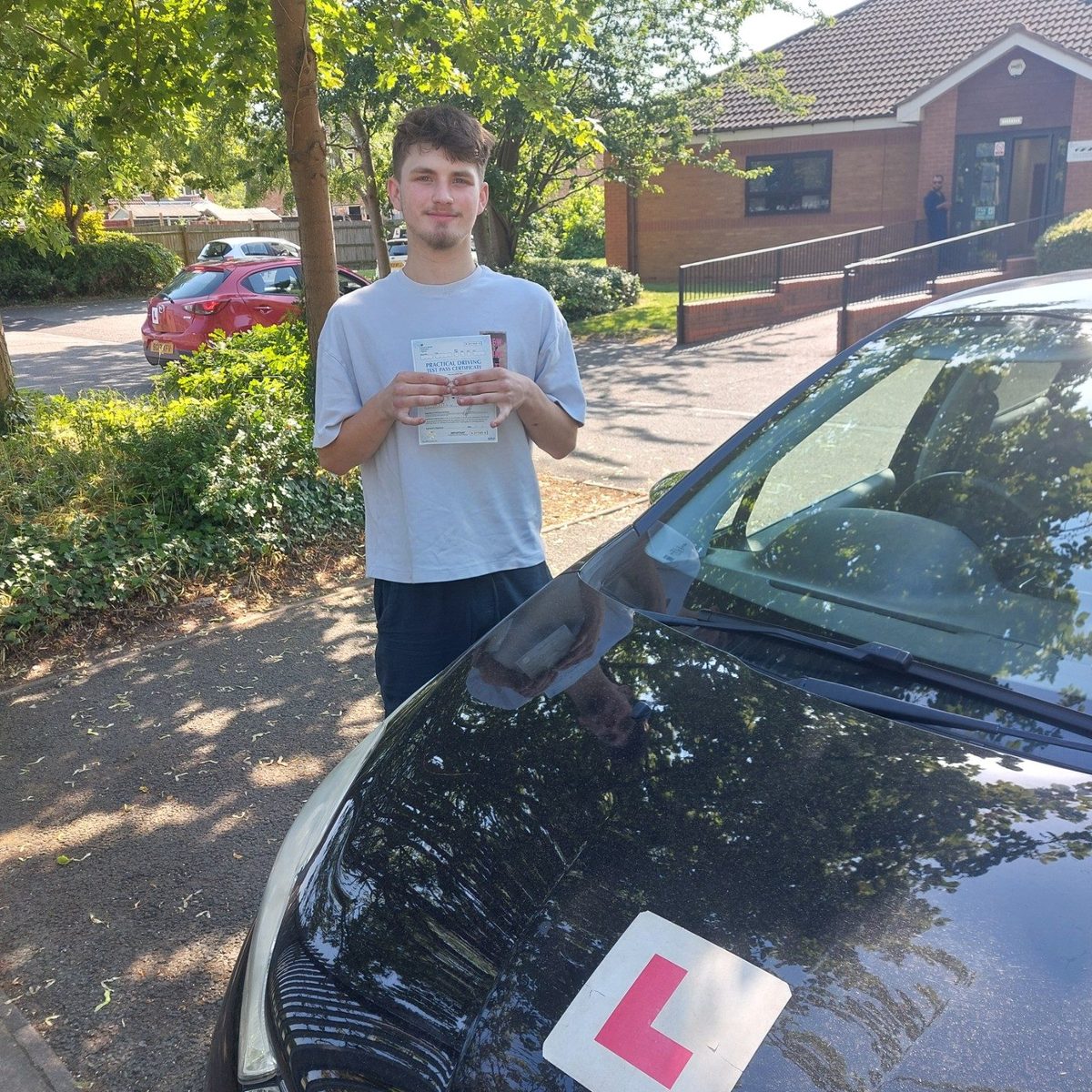 Successful Mals Driving School pupil holding a practical driving test pass certificate