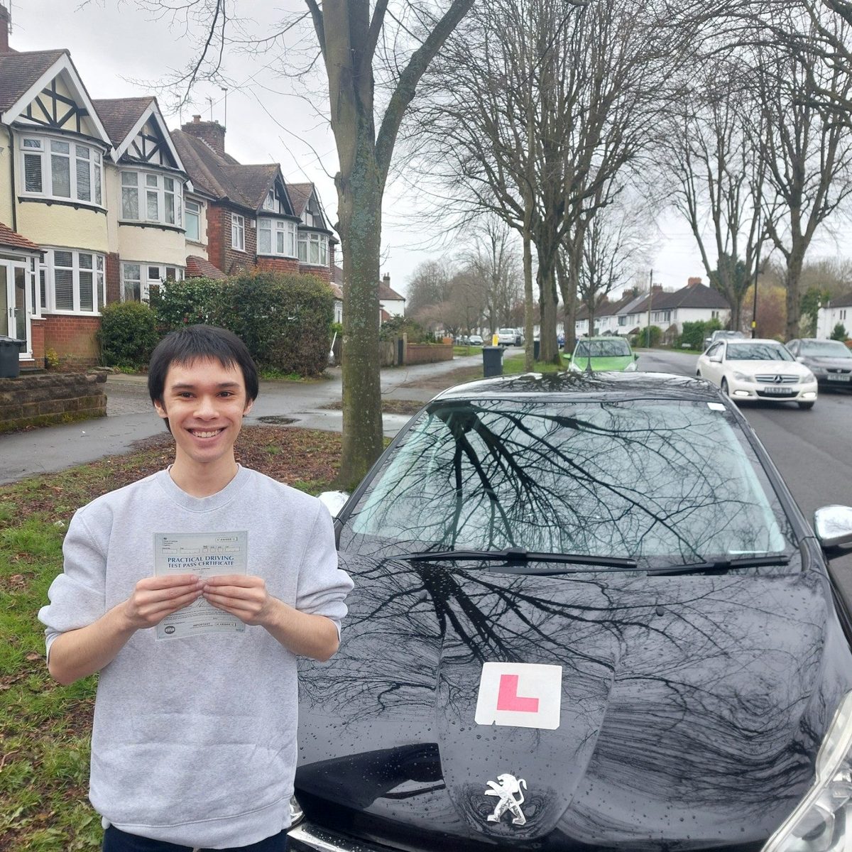 Successful Mals Driving School pupil holding a practical driving test pass certificate