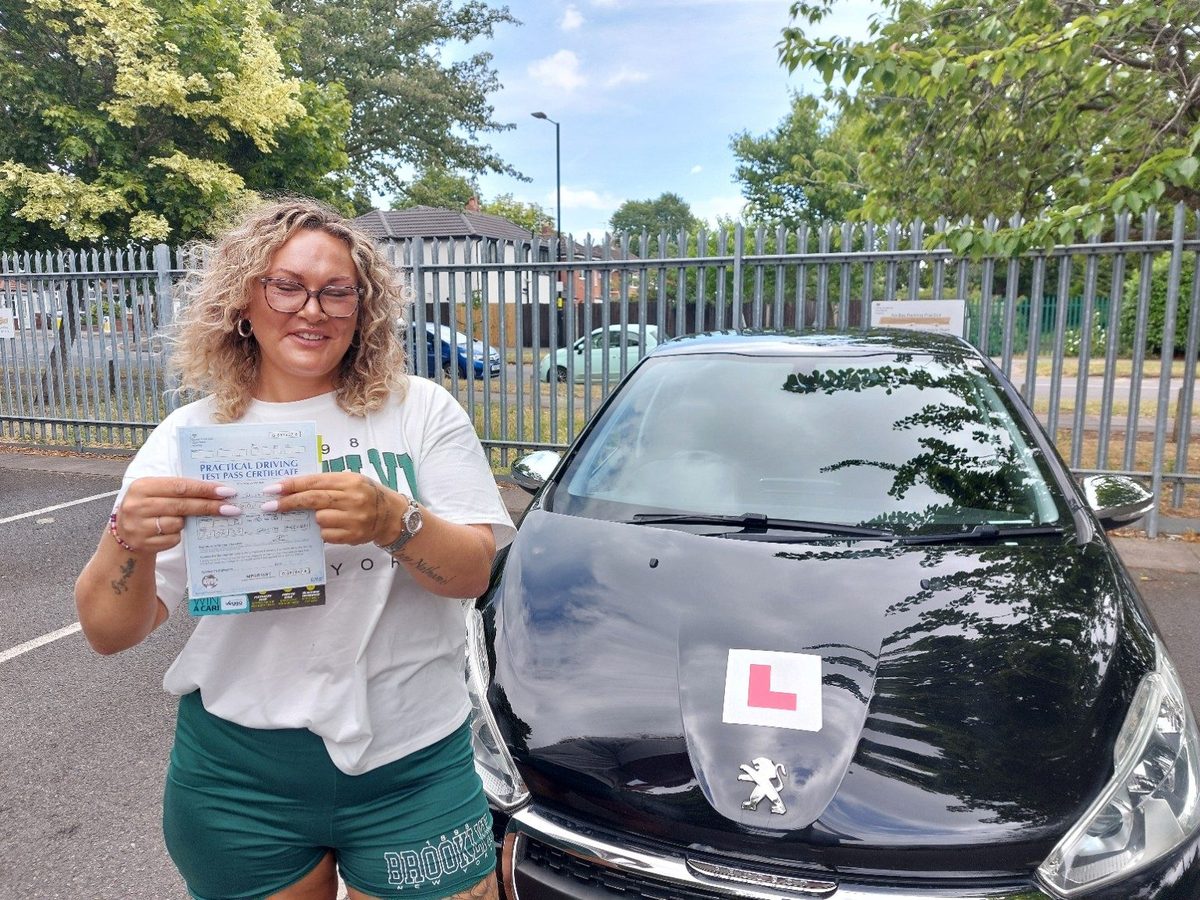 Successful Mals Driving School pupil holding a practical driving test pass certificate