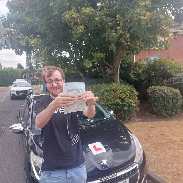 Successful Mals Driving School pupil holding a practical driving test pass certificate