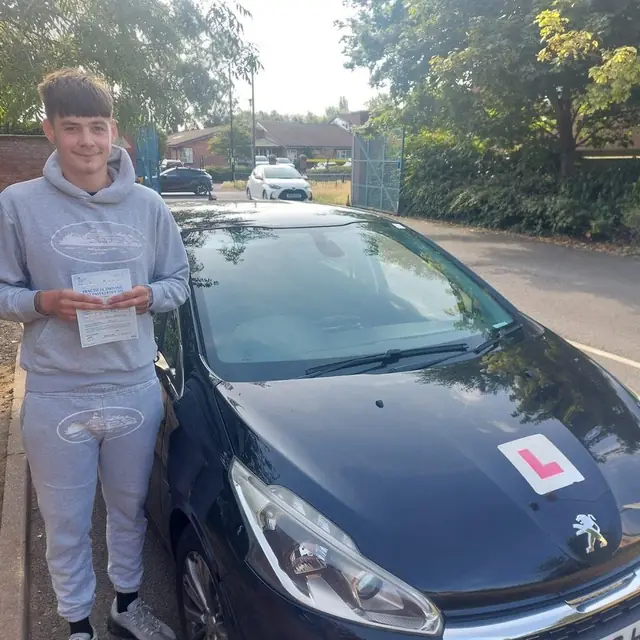 Successful Mals Driving School pupil holding a practical driving test pass certificate