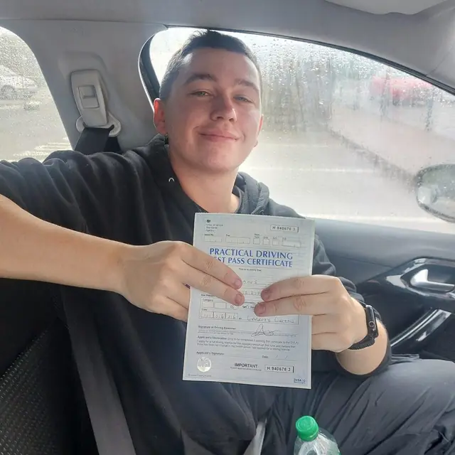 Successful Mals Driving School pupil holding a practical driving test pass certificate