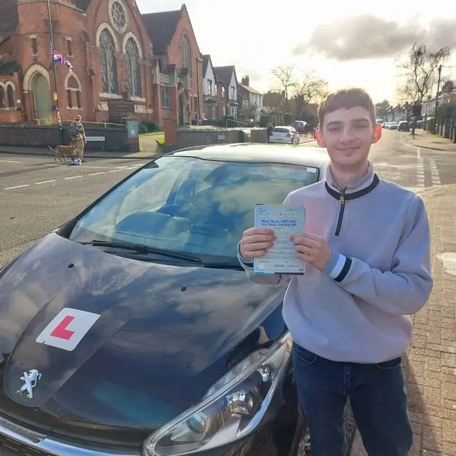 Successful Mals Driving School pupil holding a practical driving test pass certificate