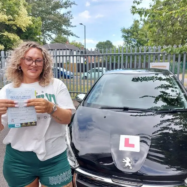 Successful Mals Driving School pupil holding a practical driving test pass certificate