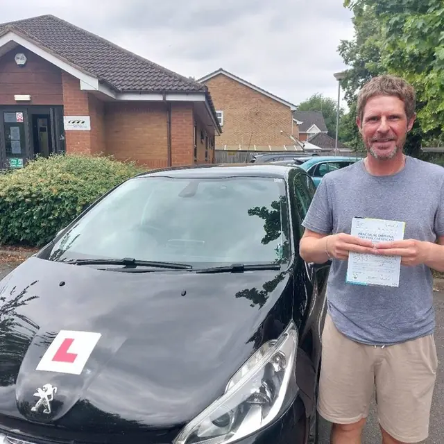 Successful Mals Driving School pupil holding a practical driving test pass certificate