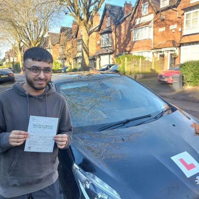 Successful Mals Driving School pupil holding a practical driving test pass certificate